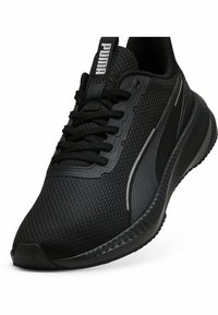 Chaussure de sport noire avec une tige en mesh, des superpositions synthétiques texturées et une semelle en caoutchouc épaisse. Comprend un branding distinctif et des lacets.