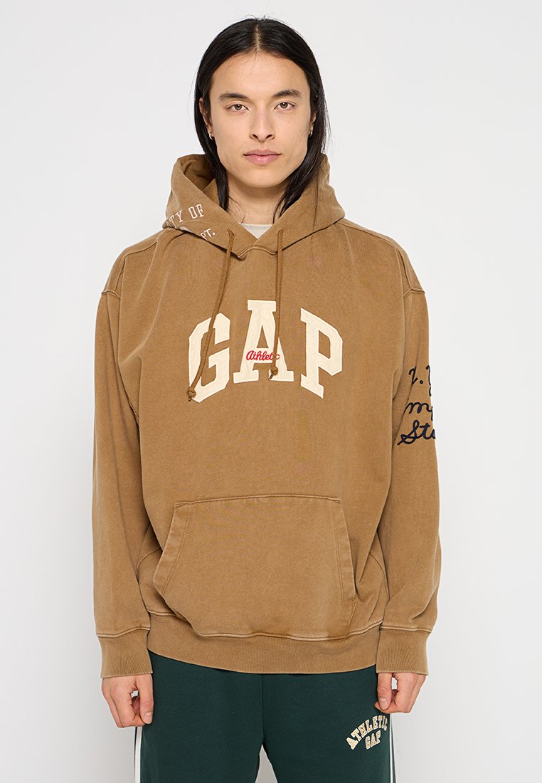 Brauner Hoodie aus Baumwolle mit einem großen "GAP"-Logo in Creme und Rot, einer Kapuze mit Kordelzug und Seitentaschen. Schlichte Schriftzüge auf dem Ärmeln.
