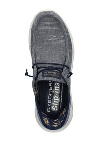Zapato slip-on de Skechers en tejido azul oscuro, con un upper texturizado, cordones elásticos y una suela blanca con un forro interior estampado.