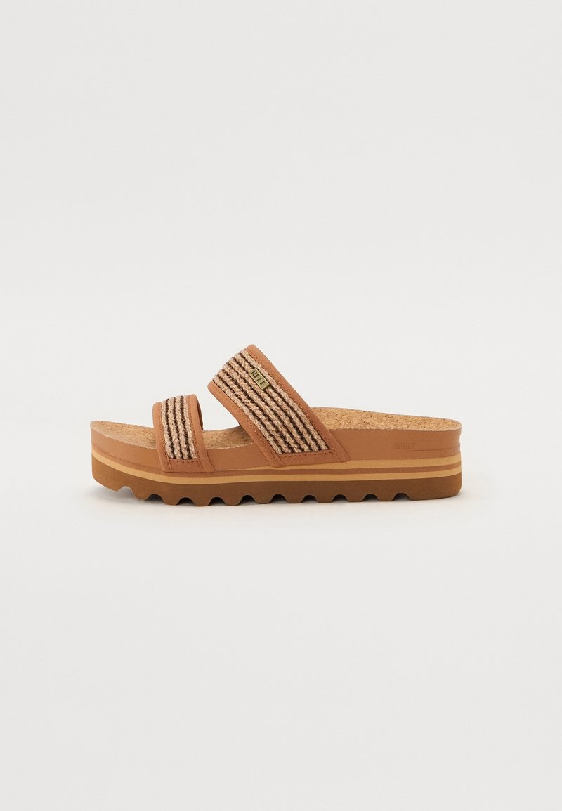 Sandale slide marron avec deux brides en tissu tissé, semelle intérieure en liège et semelle extérieure en caoutchouc rainurée avec un design en couches.