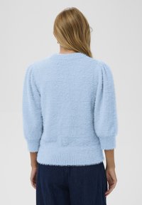 Jasnoniebieski puszysty sweter z okrągłym dekoltem, krótkimi bufkami i prążkowanym zakończeniem, charakteryzujący się miękką teksturą i swobodnym krojem.