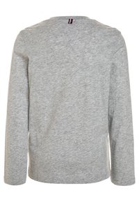 Long-sleeve gray shirt made of soft, lightweight cotton. Features a round neckline and a small, colorful label at the back.
