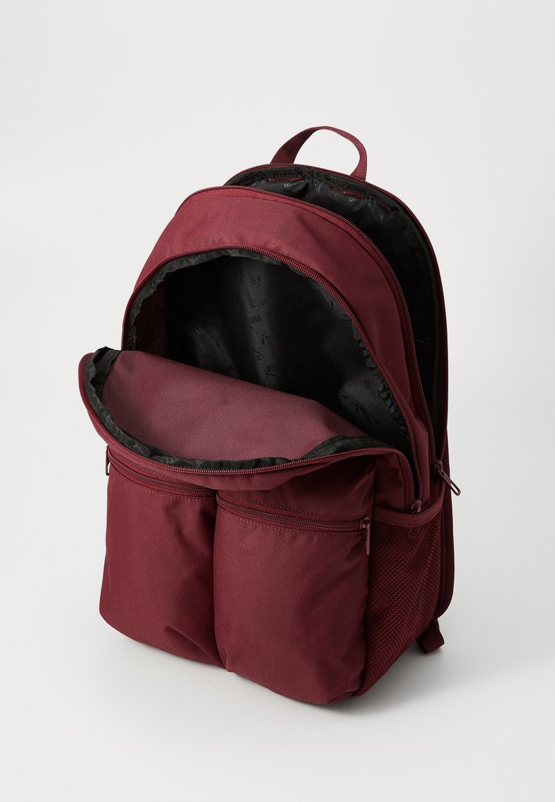 Bordeauxroter Rucksack mit einem großen Hauptfach und zwei Reißverschluss-Vordertaschen. Hergestellt aus strapazierfähigem Stoff, mit einem glatten schwarzen Innenfutter.