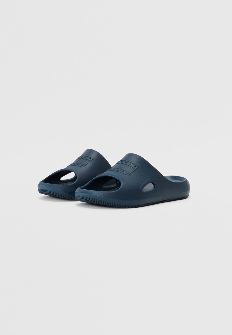 Zoccoli blu navy in gomma con apertura ampia, fori di ventilazione, suole testurizzate e logo in rilievo sulla parte superiore.