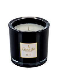 Bougie en verre noir avec un intérieur en cire blanche, une mèche centrée et une étiquette accentuée en or affichant "Gisada Switzerland IRIS."