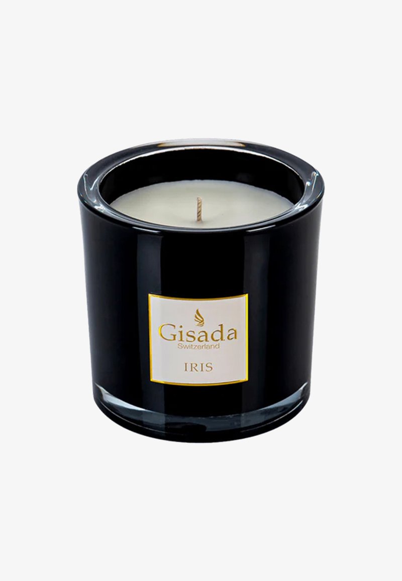 Vela de vidrio negro con un interior de cera blanca, una mecha centrada y una etiqueta con acentos dorados que muestra "Gisada Suiza IRIS."