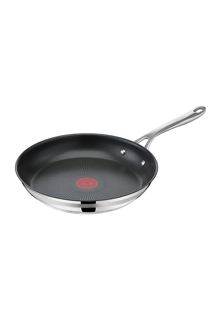 Antihaft-Bratpfanne mit schwarzem Innenleben, silbernem Edelstahlrand und einem roten Temperaturanzeiger in der Mitte. Langer Griff mit zwei Nieten.
