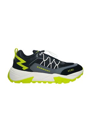 Des chaussures de sport noires et grises avec une semelle blanche épaisse et des accents verts vifs ; elles présentent un système de laçage et des détails de logo.