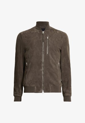 Braune Wildleder-Bomberjacke mit Stehkragen, Reißverschluss vorne, zwei seitlichen Reißverschlusstaschen sowie gerippten Bündchen und Saum. Insgesamt glatte Textur.