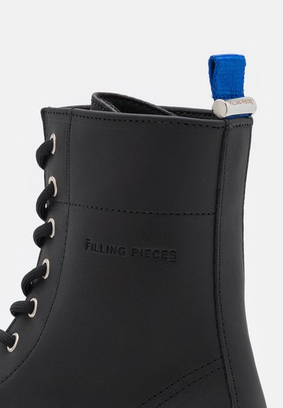 Stivale alla caviglia in pelle nera con punta tonda, hardware argento e fascia in tessuto blu sul tallone. Presenta lacci laterali e dettaglio del logo in rilievo.