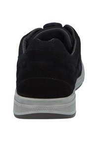 Schwarzer und grauer Sneaker von hinten betrachtet, mit einer dicken weißen Sohle und gepolstertem Knöchelkragen.