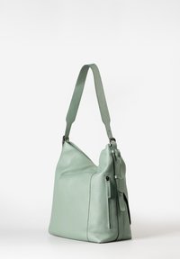 Borsa a spalla in morbida pelle verde con ampia tracolla, tasca laterale con zip e dettagli in argento, esposta su uno sfondo bianco semplice.