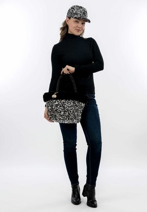 Sac à main noir et argent orné de sequins, avec un bord en fausse fourrure, une poignée tressée et un charm décoratif, accompagné d'une casquette assortie.