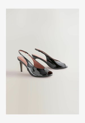 Czarne, lakierowane zamszowe sandały na obcasie z odkrytymi palcami i smukłym, średniej wysokości obcasem typu stiletto, prezentowane na jasnym tle.