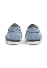 Zapatos de ante azul con un perfil bajo, punta redonda y suela de goma blanca. Presentan acentos cosidos y lazos para cordones en el talón.