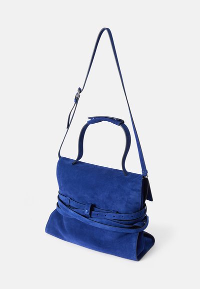 Μπλε σουέτ τσάντα σε δομημένο σχήμα, με λαβή από πάνω και αποσπώμενος ιμάντας ώμου. Περιλαμβάνει λεπτομέρεια διακοσμητικής ζώνης.