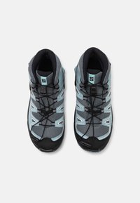 Grey and teal hiking shoes featuring mesh and rubber materials, with a high-top design, patterned laces, and molded eyelets for support.