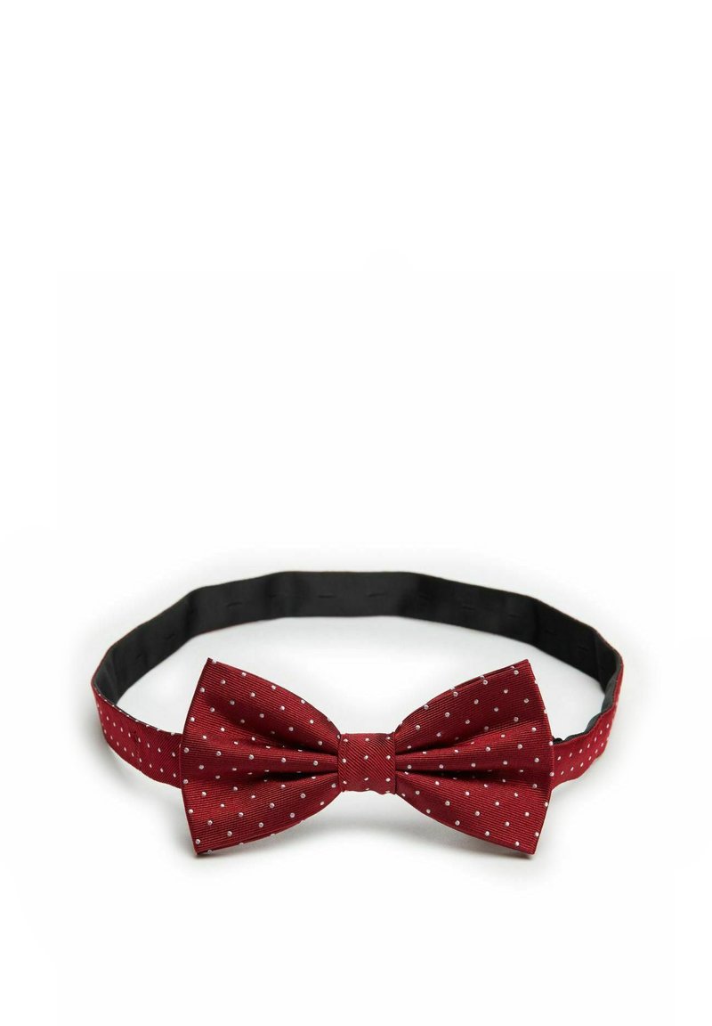 Röd prickig fluga med en texturerad tyg och ett justerbart svart band. Pricken är små och jämnt fördelade över ytan.