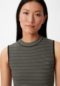 Ärmelloses Top mit einem gerippten Muster in Schwarz und metallic Silber, mit einem hohen Kragen und tailliertem Design. Sanfte Textur und dehnbare Stoffqualität.