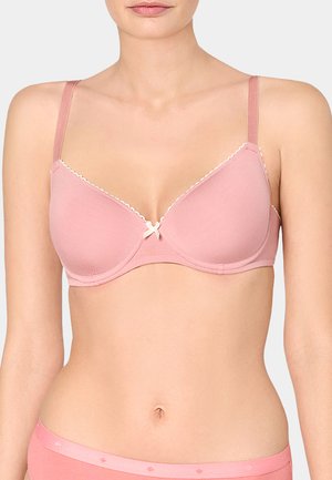 Woman wearing a light pink padded bra with thin straps and a small bow detail at the center front.