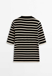 Chemise à manches courtes rayée noire et beige avec un col rond, vue de dos sur un fond blanc uni.