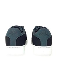 Sneakers in suede nero con dettagli grigi, una suola in gomma bianca e un'etichetta con logo sul tallone. Forma arrotondata con cuciture rinforzate.