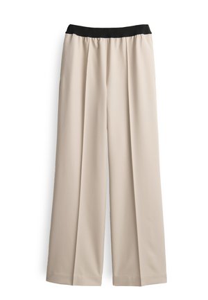 Beige wijde broek met een zwarte elastische tailleband, voorzien van een gladde textuur en subtiele voorkreuken. Geen zichtbare patronen of hardware.