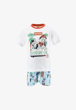Weißes kurzärmliges Schlafanzugset mit Paw Patrol Figuren und grafischem Druck. Blaue Shorts mit bunten Palmen- und Surfbrettmustern.