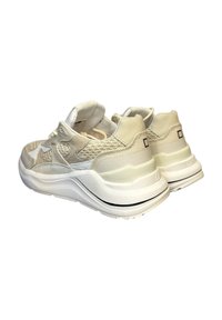 Un paio di sneakers chunky bianche e beige con tessuto testurizzato e suole spesse, mostrate da angolazioni posteriori e laterali.