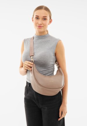 Borsa hobo in morbido tessuto color taupe con forma curva, dettaglio in oro del logo e tracolla marrone con branding in rilievo.