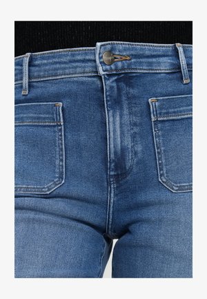 Blaue Denim-Jeans mit klassischem Fünf-Taschen-Design. Zu den Merkmalen gehören ein Metallknopfverschluss, kontrastierende Nähte und ein leicht verblasster Look.