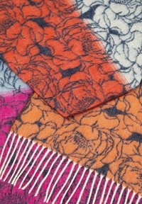 Bufanda de mezcla de lana con patrones florales en naranja y rosa, con bordes con flecos y una superficie texturizada. Incluye tonos de gris y crema.