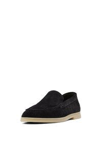 Mocassini in suede neri con design slip-on, dotati di punta arrotondata, suola chiara a contrasto e dettagli di cucitura sottili.