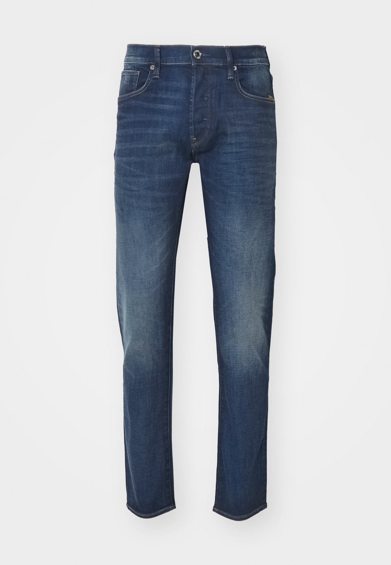 Jean slim bleu foncé avec une légère décoloration aux cuisses et aux genoux, fermeture par boutons à l'avant et design à cinq poches.