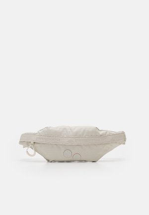 Beżowa materiałowa torba na biodro z regulowanym paskiem, zamknięciem na suwak i dwoma okrągłymi guzikowymi detalami z przodu.