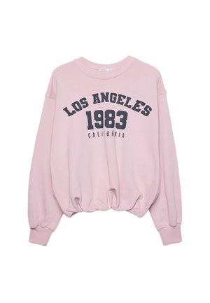 Vaaleanpunainen lyhyt huppari pitkillä hihoilla, jonka helmassa on elastisuus, ja etuosassa musta teksti "LOS ANGELES 1983 CALIFORNIA".