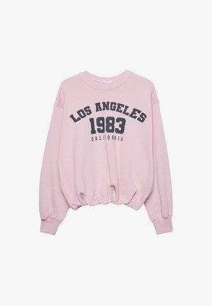 Vaaleanpunainen lyhyt huppari pitkillä hihoilla, jonka helmassa on elastisuus, ja etuosassa musta teksti "LOS ANGELES 1983 CALIFORNIA".