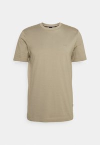 Beige kortärmad T-shirt i bomull, med rund halsringning och en liten logotyp på bröstet. Slät textur och avslappnad passform.