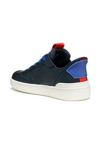 Baskets navy avec lacets bleus et onglet de talon rouge, présentant une tige en cuir lisse et une semelle en caoutchouc blanc. Accent sur les éléments de design sportif.