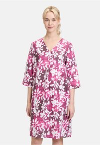 Blumenkleid in Pink- und Weißtönen, mit V-Ausschnitt und dreiviertelärmeln. Hergestellt aus leichtem Stoff mit lockerer Passform.