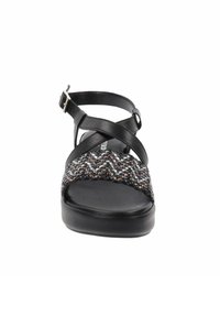 Sandalo nero con motivo intrecciato multicolore sulla fascia, suola piatta e fascette incrociate per supporto. Chiusura con fibbia alla caviglia.