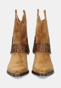 Botas de tobillo de gamuza en tono arena con punta afilada, que cuentan con una amplia correa de cuentas brillantes alrededor de la parte media del pie y lengüetas para facilitar su uso.