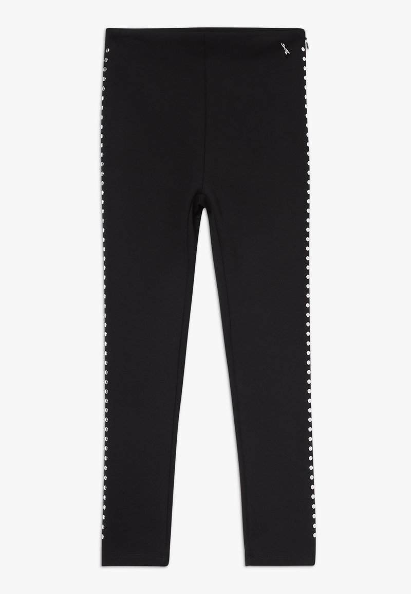 Zwarte legging van een gladde, rekbare stof met zilveren studs langs de buitennaad. Enkel lengte met een strakke pasvorm.