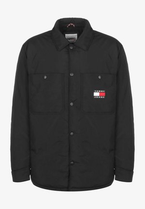Schwarze Jacke mit Knöpfen und zwei Brusttaschen vorne, eine davon mit einem Tommy Jeans-Logo in Rot, Weiß und Marineblau.