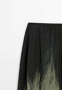 Jupe dégradée noire avec un design fluide, un tissu léger et une taille élastique, passant de teintes sombres à des teintes plus claires.