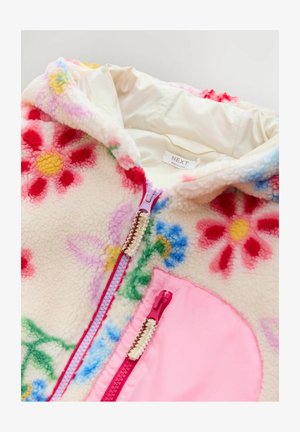 Flis jakna s kapuco z cvetličnim vzorcem v roza, rumeni in modri barvi na kremnem ozadju. Ima roza zadrgo in poudarjene žepne detajle.