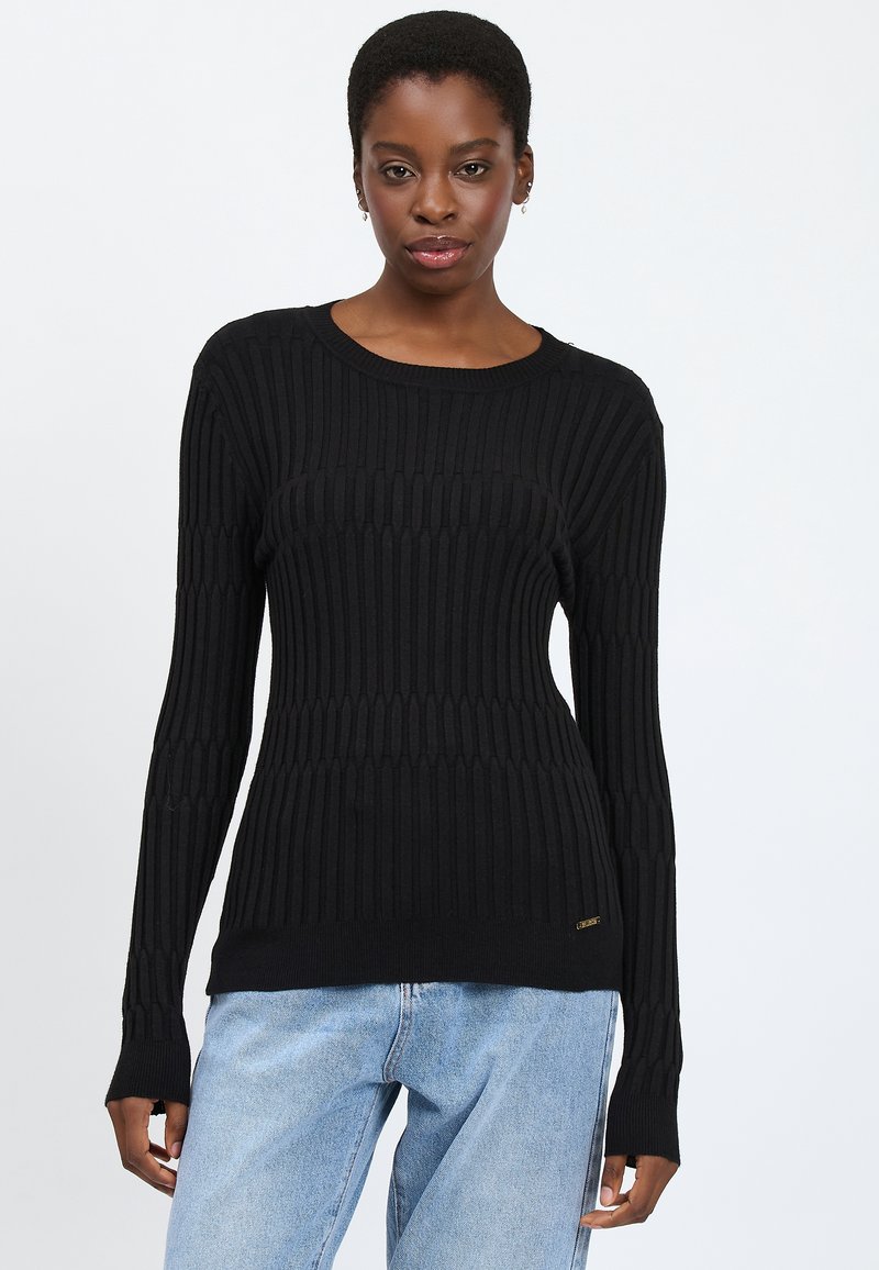 Maglione a costine nero con maniche lunghe, scollatura rotonda e sottile accento del marchio sull'orlo. Texture liscia, silhouette aderente.