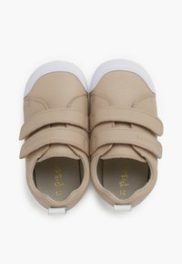 Scarpe in ecopelle beige con suola in gomma bianca, dotate di due cinturini in velcro e punta arrotondata. Interno foderato in materiale morbido.