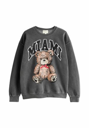 Mørkegrå sweatshirt med teksten "MIAMI" over en brun tøjdyrsbamse iført rød butterfly trykt på forsiden.