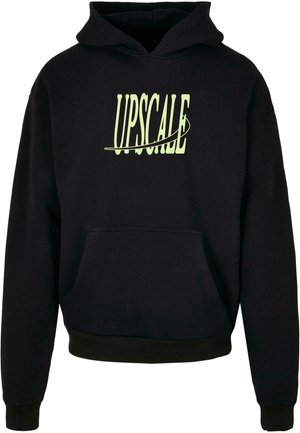 Czarna bluza z kapturem i kieszenią z przodu oraz bladożółtym napisem "UPSCALE" przekreślonym zakrzywioną linią na piersi.